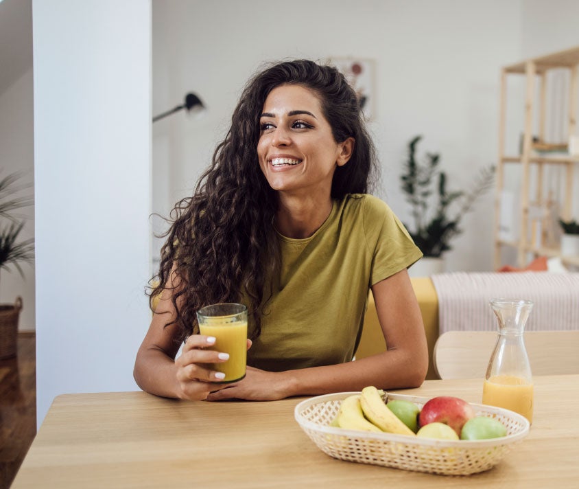 Girl smiling holding glass of orange juice